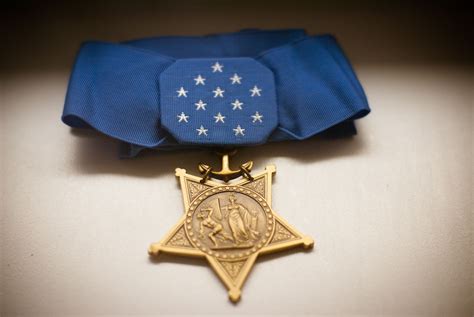 an award medal with a blue ribbon around it and a gold star on the front