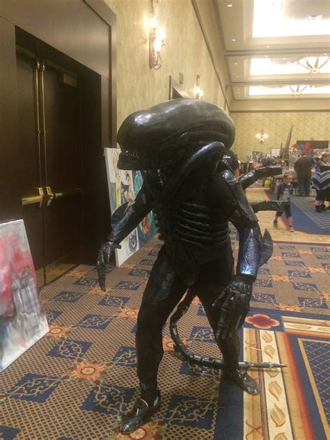 a large alien statue standing on top of a carpet