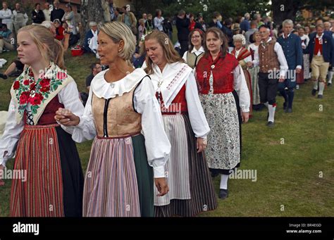 Couples in traditional Swedish folk costumes parade at midsummer celebration. Naas castle estate ...