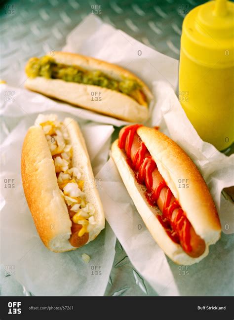 Three hot dogs with different condiments stock photo - OFFSET