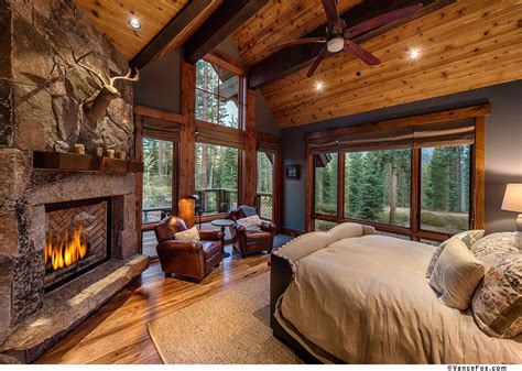 A master bedroom fit for the king of the mountain featuring a custom stone fireplace and faux ...