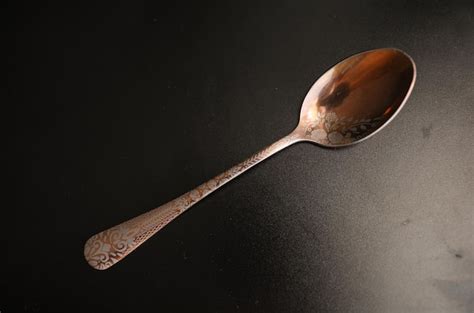 Premium Photo | A spoon with a floral pattern on it is sitting on a black surface.