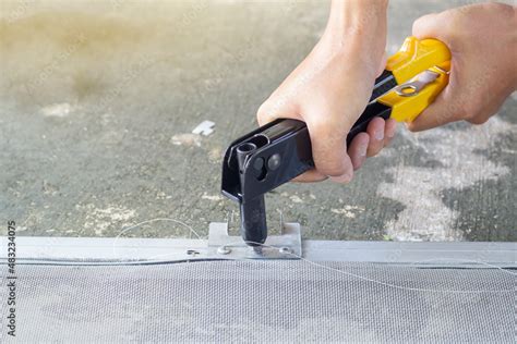 Mechanic uses pneumatic rivet gun to install a rivet on aluminum sheet ...