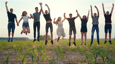 Happy Friends Jumping Holding Hands at Sunset. Stock Photo - Image of ...