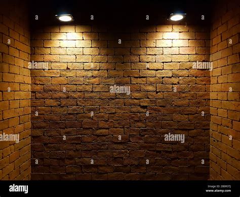 abstract old brick wall in the dark with two spotlight, warm light tone. brick wall in empty ...