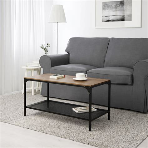 a living room with a gray couch, coffee table and white rug on the floor