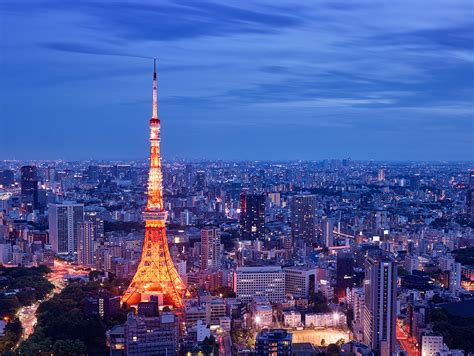 tokyo tower at dusk night lights blue sky city below from above long exposure lights orange ...