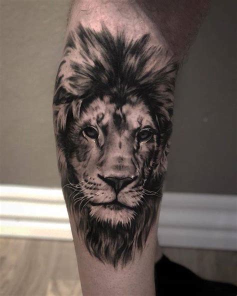 Black and grey lion tattoo on the calf.