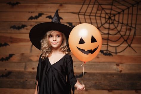 Premium Photo | Halloween Witch concept - little caucasian witch child enjoy with halloween ...