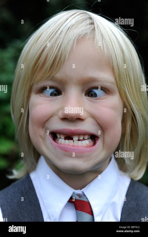 6 year old school girl pulling a silly face with a missing front tooth ...