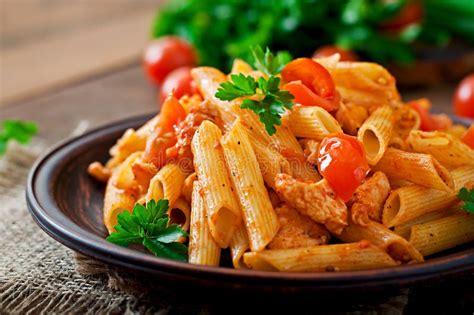 Pâtes De Penne En Sauce Tomate Avec Le Poulet, Tomates Décorées Du Persil Photo stock - Image du ...