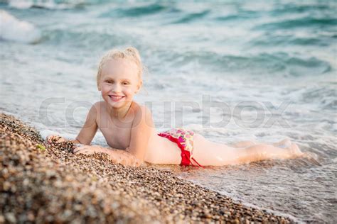 Happy little girl lying on the beach | Stock image | Colourbox