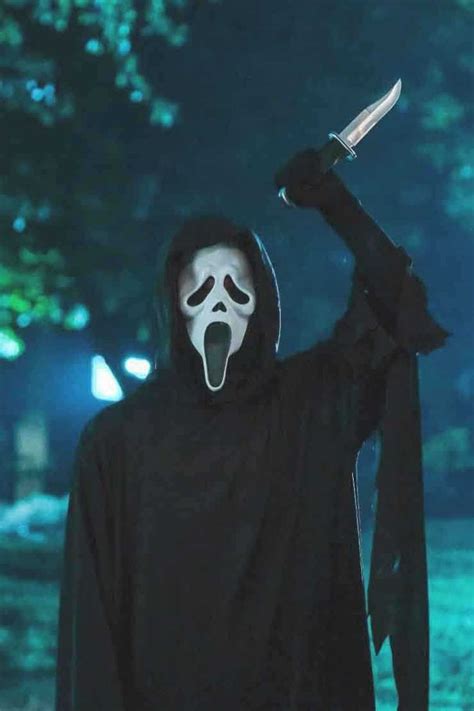 a person in a black hooded costume holding a knife