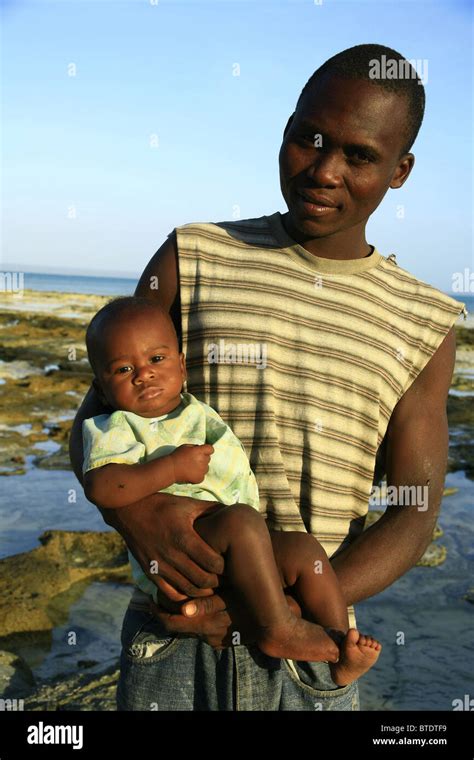 Black man holding a baby Stock Photo - Alamy