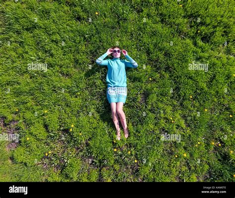 beautiful girl lying down of grass. The girl lies in a turquoise dress on the lawn Stock Photo ...