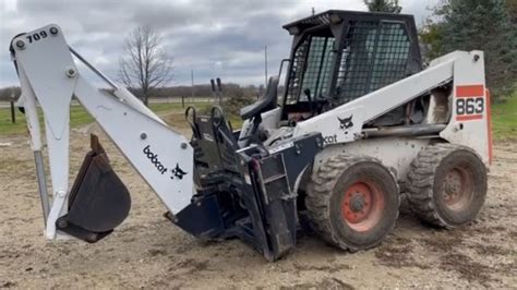 Bobcat 863 with a Bobcat 709 Backhoe Attachment | Belted Galloway Homestead - YouTube