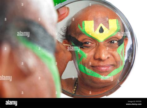 South Indian kathakali dancer applying makeup looking in mirror ; Kerala ; India MR#761C Stock ...