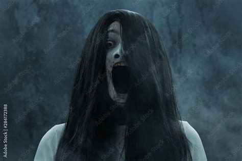 Scary ghost woman screaming on dark background Stock Photo | Adobe Stock