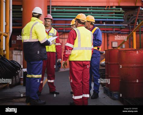 Workers talking on oil rig Stock Photo - Alamy