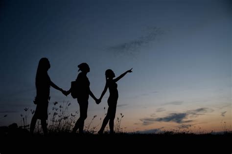 Premium Photo | Friends holding hands at sunset.