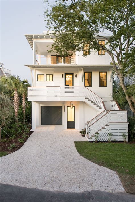 Beautiful 3 storied white home exterior with black doors and windows ...