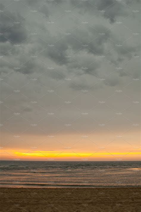 Beach at sunset with stormy clouds | Nature Stock Photos ~ Creative Market