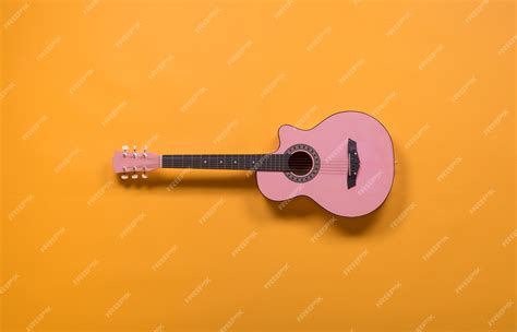 Premium Photo | Pink guitar on a yellow background