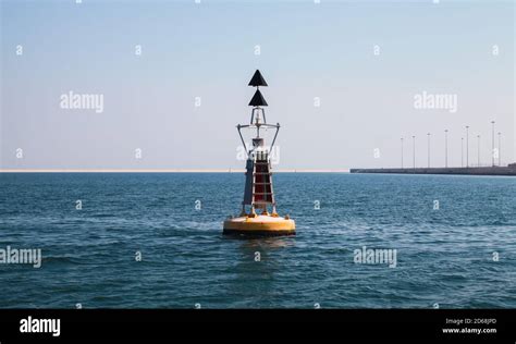 North Cardinal buoy is on sea water. standard yellow black navigational sign with double conical ...