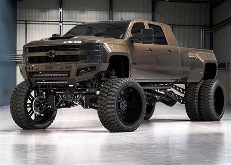 a brown truck with big tires in a garage area, on display at an ...