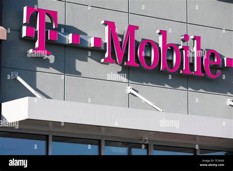 A logo sign outside of a T-Mobile retail store location in Martinsburg ...