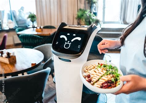 Robot waiter serve food at modern restaurant table.Offering innovation futuristic high-tech ...