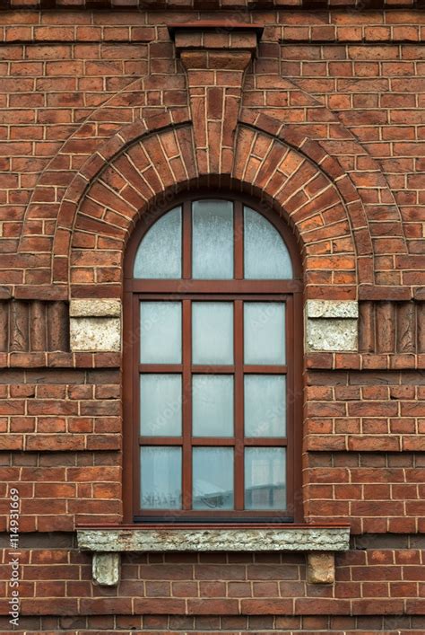 Window with an arch on the background wall of brown brick. From the ...