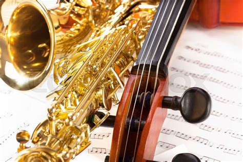 Violoncello tuning pegs and shiny alto saxophone | Stock image | Colourbox