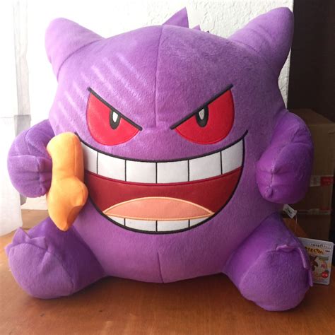 a purple stuffed animal with red eyes and big teeth