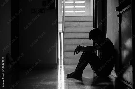 Silhouette of man sitting alone,Sad and Serious Man sitting hug his ...