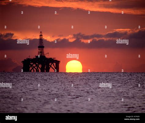 Oil rig at sunset Stock Photo - Alamy