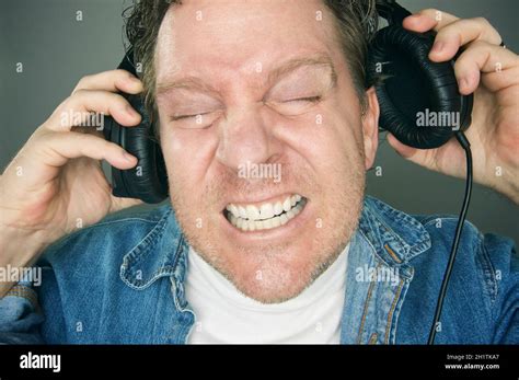 Shocked Man Desperately Trying To Take Off His Headphones Stock Photo - Alamy