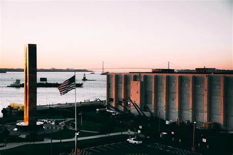 Usa Flag in Front of Building Near Ocean · Free Stock Photo