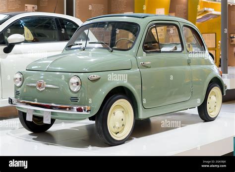 Green 1957 original Fiat 500 car on display in a motor showroom, an ...