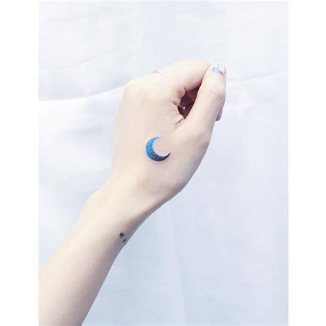 Blue spectrum moon tattoo on the left hand.