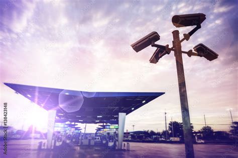 Closed circuit television camera at gas station in sunset sky. Stock Photo | Adobe Stock