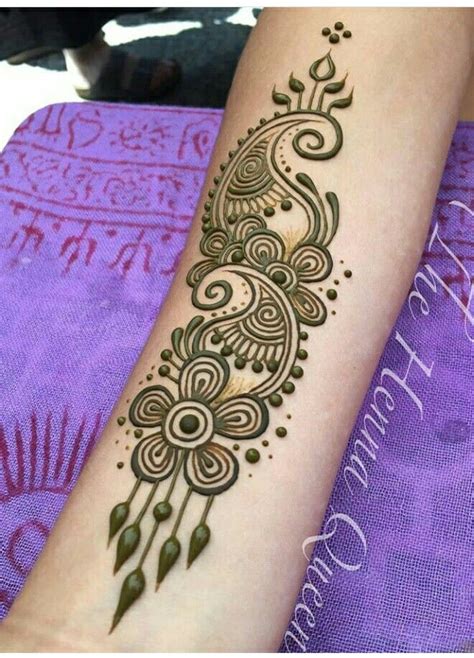 a woman's arm with henna tattoos on it