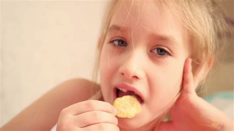 Indoor Snacking: Young Girl Enjoying Chips Stock Footage SBV-320353164 - Storyblocks