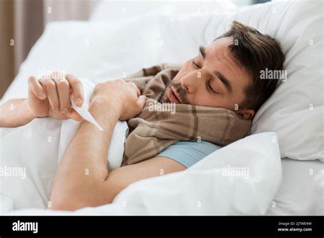 sick man measuring temperature by thermometer Stock Photo - Alamy