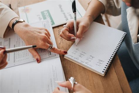 Person Writing Notes on Her Notebook · Free Stock Photo