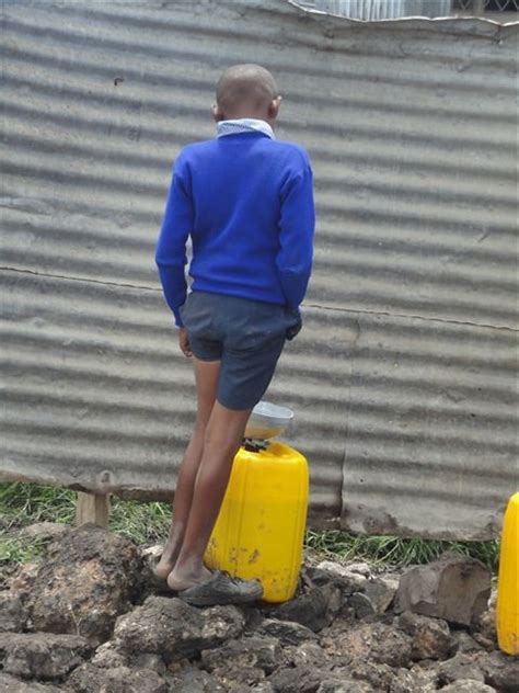 Tall boy using the uni-sex urinal in Nairobi school | Flickr