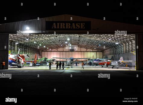 Airbase aircraft aviation museum at Coventry airport. Hangar full of planes at night with ...