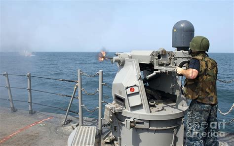 Gunners Mate Fires A 25mm Chain Gun Photograph by Stocktrek Images