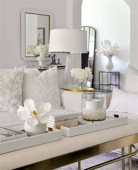 a living room filled with white furniture and flowers on top of a ...