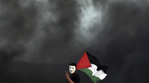 protester with Palestinian flag at protest at the Gaza border with Israel